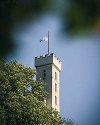 Low angle view of tower by building against sky