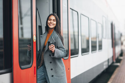 Woman standing on train at railroad station