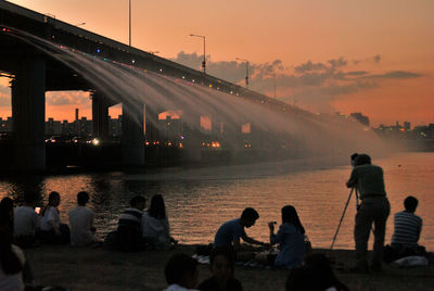 People walking in water at sunset