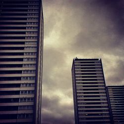 Low angle view of modern building against cloudy sky