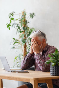 Businessman with head n hands at desk in office