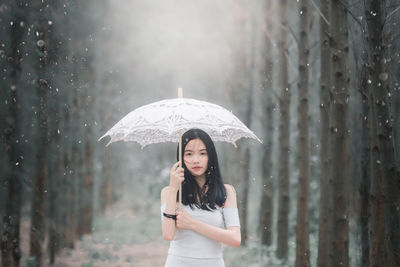 Young woman standing on wet glass during rainy season