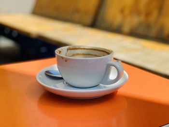 Close-up of coffee cup on orange table