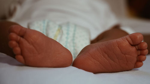 Close-up of baby feet on bed