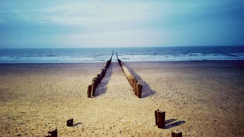 Text on sand at beach against sky