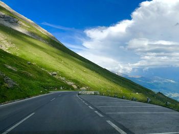 Road amidst green landscape against sky