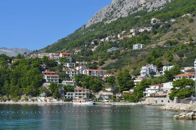 Town by sea and buildings against sky