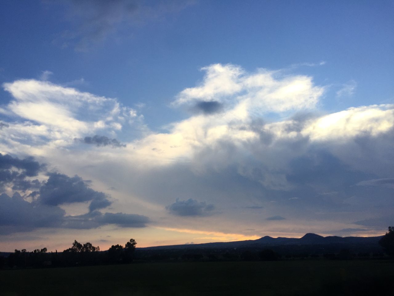 tranquil scene, landscape, sky, tranquility, scenics, silhouette, beauty in nature, mountain, cloud - sky, nature, cloud, blue, idyllic, non-urban scene, horizon over land, mountain range, field, sunset, outdoors, remote