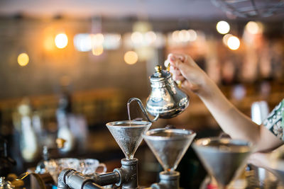 Cropped hand of woman pouring coffee in espresso maker