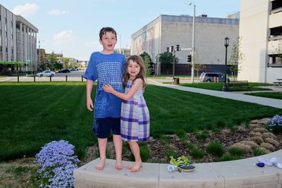 Portrait of siblings standing against nebraska state capitol building 