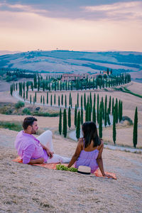 People sitting on land against sky