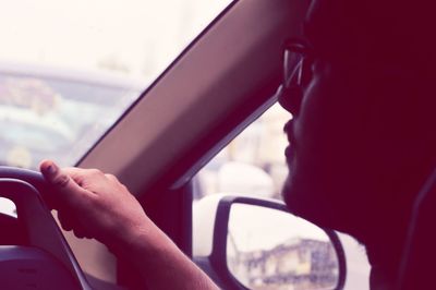 Midsection of man seen through car window