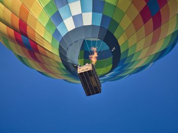 Low angle view of hot air balloon against clear blue sky