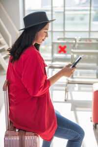 Side view of young woman using mobile phone