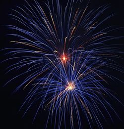 Low angle view of firework display against sky at night