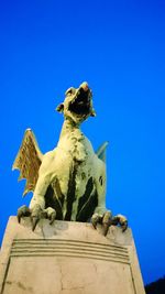 Low angle view of statue against clear blue sky