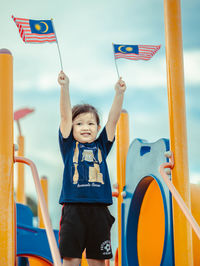 Full length of boy with arms raised