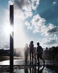 People standing on shore against sky