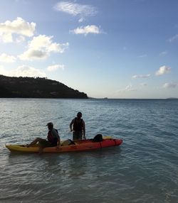 People in boat on sea against sky