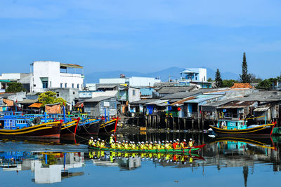 Boats moored in water against sky