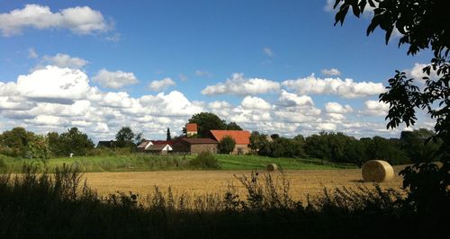 Rural landscape against cloudy sky