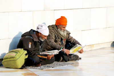 People sitting on floor against wall