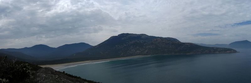 Scenic view of sea and mountains against sky