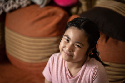 Close-up of cute girl sitting at home