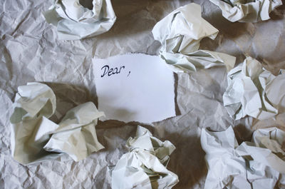 High angle view of dear text by crumpled paper on table