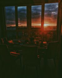 Chairs and table against sky seen through window