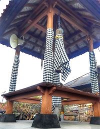 Low angle view of cross amidst buildings against sky