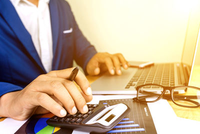 Midsection of man using laptop on table