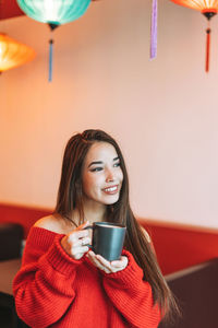 Portrait of young woman drinking coffee