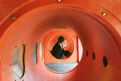 Reflection of man on orange mirror