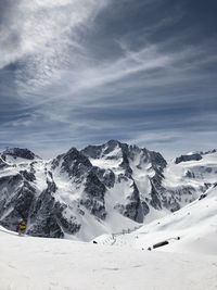 Scenic view of snow covered mountains against sky