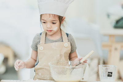 Portrait of a girl holding ice cream at home