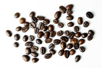 High angle view of coffee beans against white background