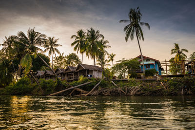 Houses by river against sky