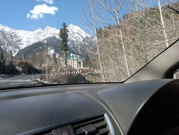 Snow covered car seen through windshield