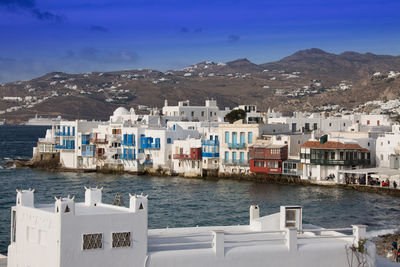 Houses by sea against clear sky