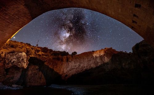 Scenic view of rock formation against sky at night