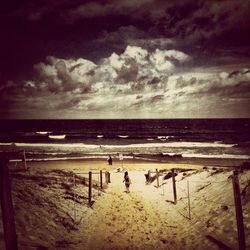 Scenic view of beach against cloudy sky