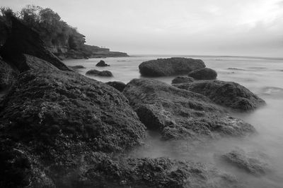 Rocks on beach against sky