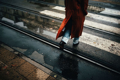 Low section of woman standing on railroad tracks