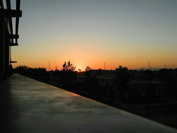 Silhouette houses against clear sky at sunset