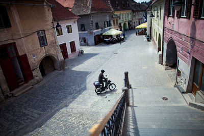 Man riding bicycle on road in city