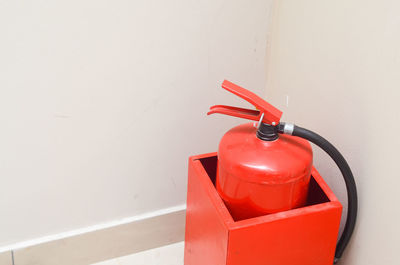 Close-up of fire extinguisher against wall