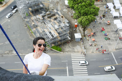Caucasian woman wearing hero costume descending a tall building in rappel. salvador bahia brazil.