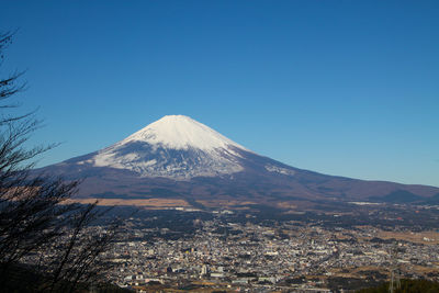 Aerial view of snowcapped mountain against blue sky