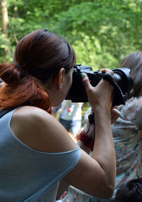 Side view of photographing woman 